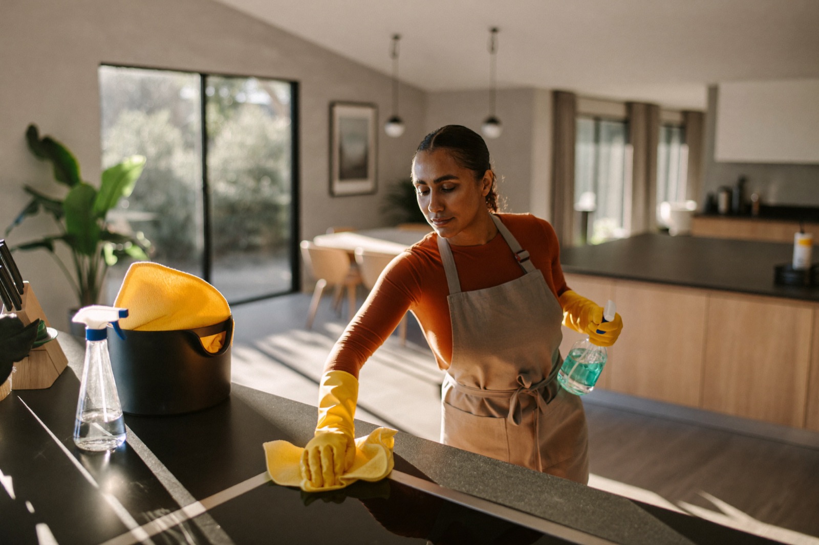 Maidstream Cleaning professional in yellow gloves wiping down a kitchen counter in a Dayton, Ohio home